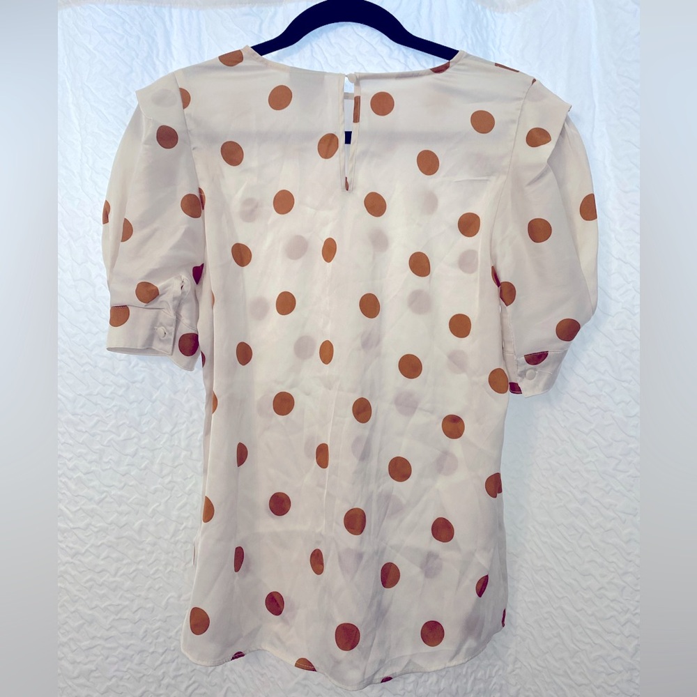 satin white blouse with orange polka dots.